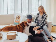 a man and woman sitting on a couch with their dog