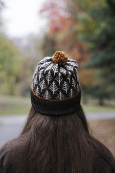 a woman with long hair wearing a black and white knitted hat on top of her head