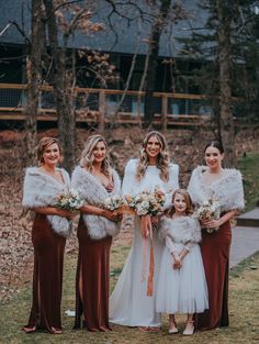 a group of women standing next to each other in front of some trees and grass