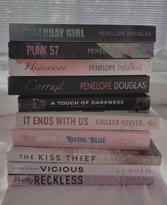 a stack of books sitting on top of a bed