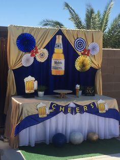 a table topped with a bottle of beer next to a blue and white sign that says cheers