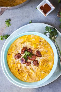 a bowl of food on a plate with spoons