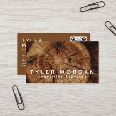 a wooden business card sitting on top of a table next to some paper clip holders