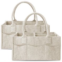 three bags with handles are stacked on top of each other, one is beige and the other is white