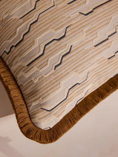 an upholstered pillow with fringes on it