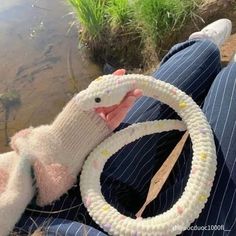 a person holding a steering wheel made out of knitted yarns and wool balls