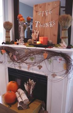 a mantel decorated with branches and pumpkins