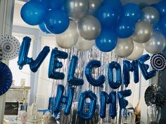 blue and silver balloons are hanging from the ceiling