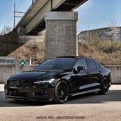 a black car parked in front of a bridge