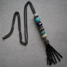 a necklace with beads and tassels is laying on the ground