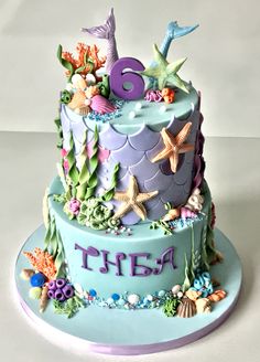 a birthday cake decorated with sea animals and seashells