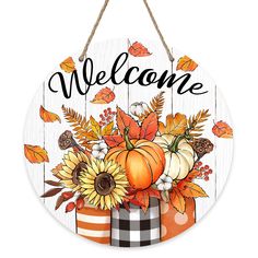 a welcome sign hanging on a wall with pumpkins and sunflowers in it