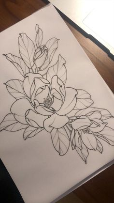 a drawing of some flowers on a piece of paper that is sitting on a table