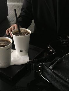 two cups of coffee sitting on top of a table