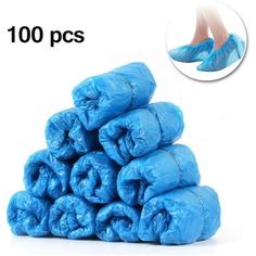 blue plastic bags are stacked on top of each other with one person's feet in the background