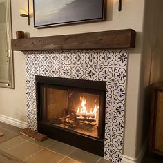 a fire place in a living room with tile on the wall and wood trimming