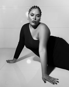 a woman is laying on the floor in black and white