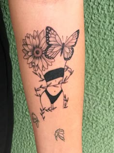 a woman's arm with a butterfly and sunflower tattoo on it