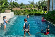 children are playing in the pool while adults watch