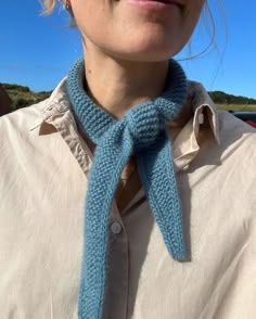 a woman wearing a blue knitted neck tie