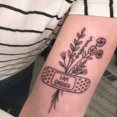 a woman's arm with a tattoo on it that says i am enough and flowers