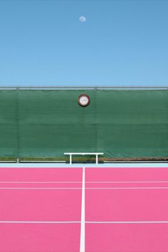 a pink tennis court with a clock on it