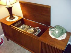 an old fashioned record player is sitting on top of a dresser in the corner of a room