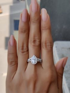 a woman's hand holding an engagement ring