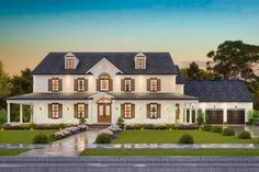 a large white house with lots of windows and bushes in the front yard at dusk