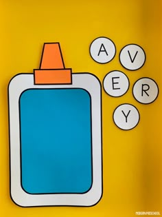 a blue bottle with an orange top sitting next to three circles that spell out the word avery