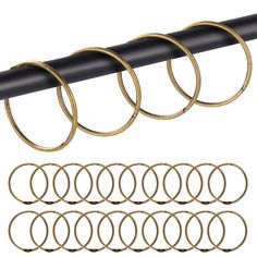 six pairs of gold rings hanging from a black pipe