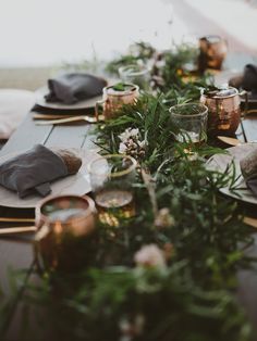 the table is set with candles, plates and napkins