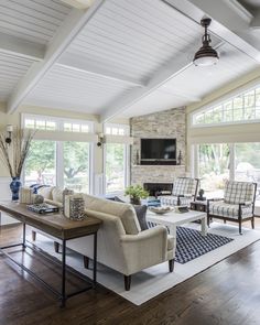 a living room filled with furniture and a flat screen tv mounted on the wall above a fireplace