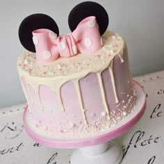 a pink and white cake decorated with minnie mouse ears