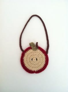 a small crocheted bag with a smiling face on it's front end