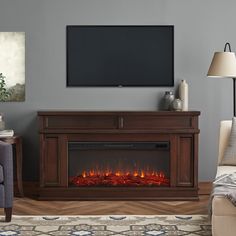 a living room with a fireplace and television on the wall in front of an entertainment center