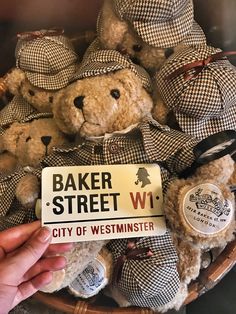 a basket full of teddy bears with a sign that says baker street wi city of westminster