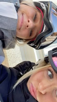 two women wearing helmets and goggles are posing for the camera with their faces close together