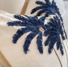 a close up of a pillow with blue feathers on it