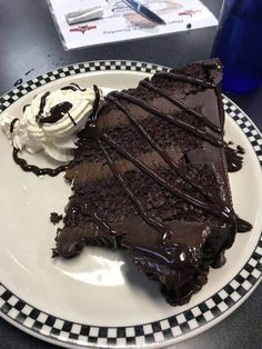 a piece of chocolate cake and ice cream on a plate with checkerboard border