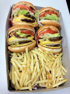 several hamburgers and french fries in a box