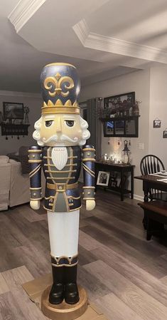 a large wooden nutcracker standing on top of a hard wood floor