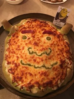 a pizza with a face drawn on it