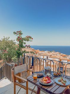 an outdoor table with food on it overlooking the ocean