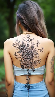 the back of a woman's body with tattoos on it