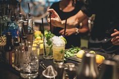 bartenders are preparing cocktails at the bar