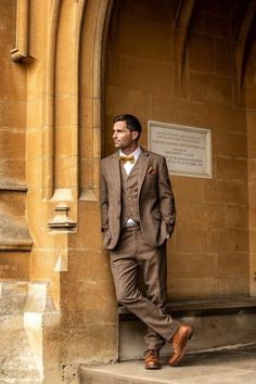 a man in a suit leaning against a wall