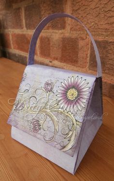 a handbag sitting on top of a wooden table next to a brick wall with flowers painted on it