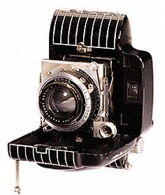 an old camera sitting on top of a stand