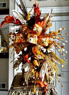 an arrangement of dried flowers and feathers on display